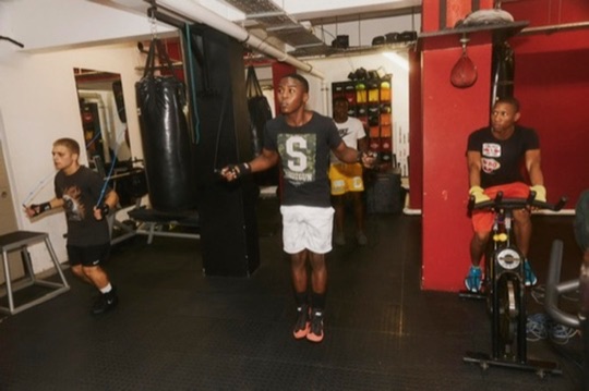 A group of boxers stands together on the gym floor.