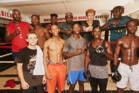 A large boxing team gathers for a group photo in the gym.
