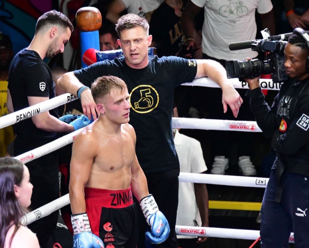 A boxer listens to his corner team between rounds.
