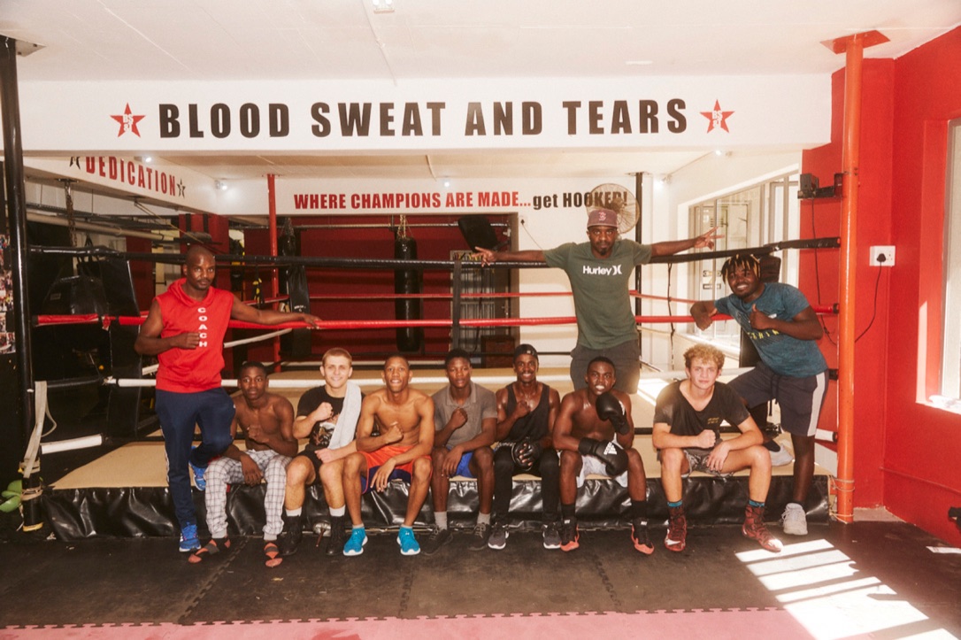 A boxing team gathers around the ring for a group portrait.