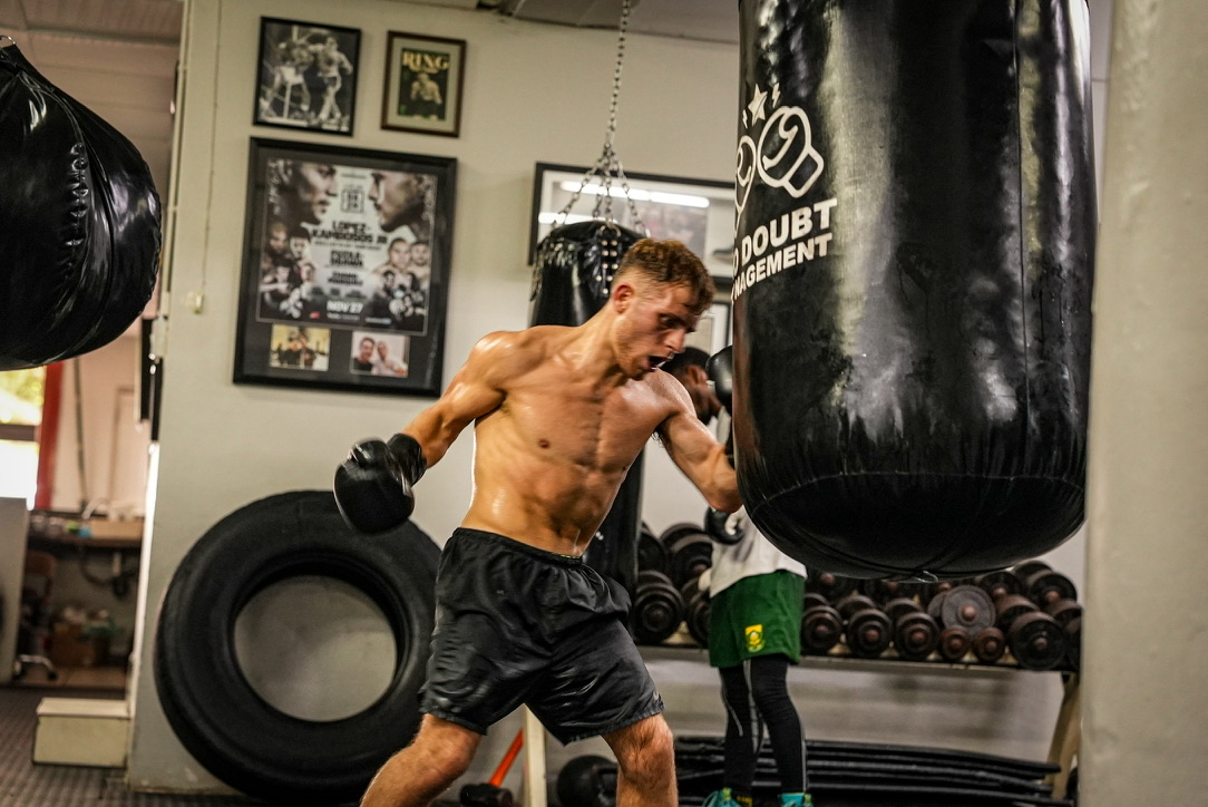 A boxer striking a heavy bag during training.