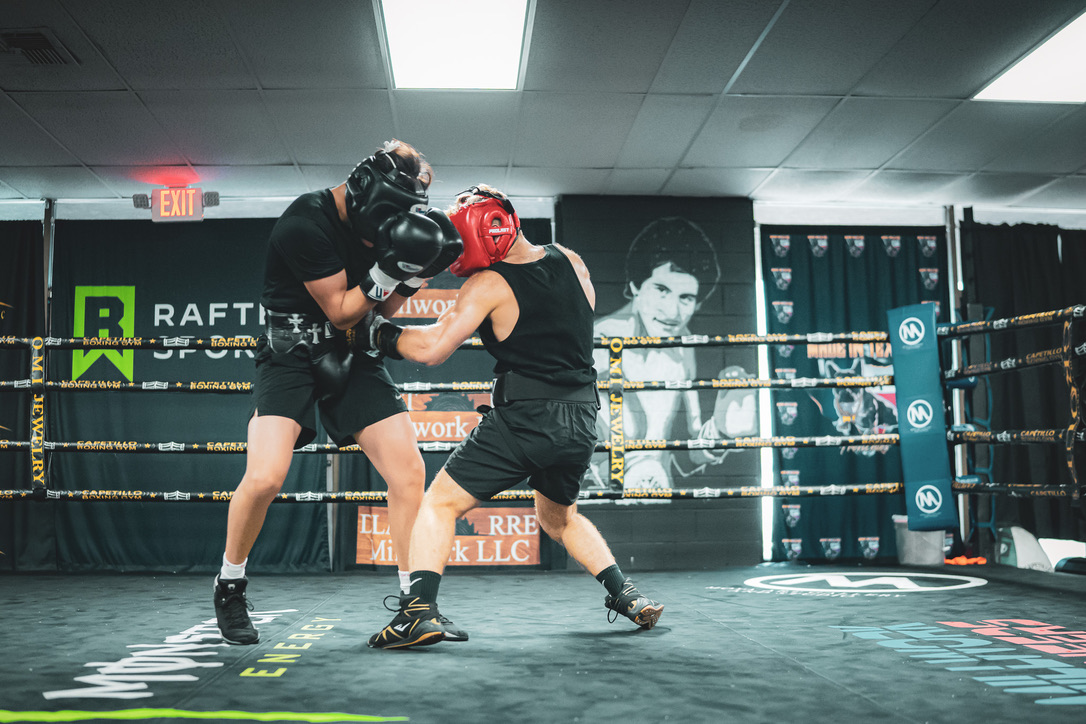 Two boxers sparring inside a boxing ring.