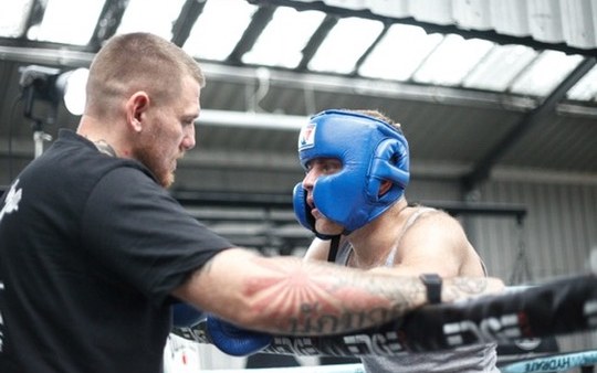 Boxing coach holding pads for a client at Top Floor Boxing