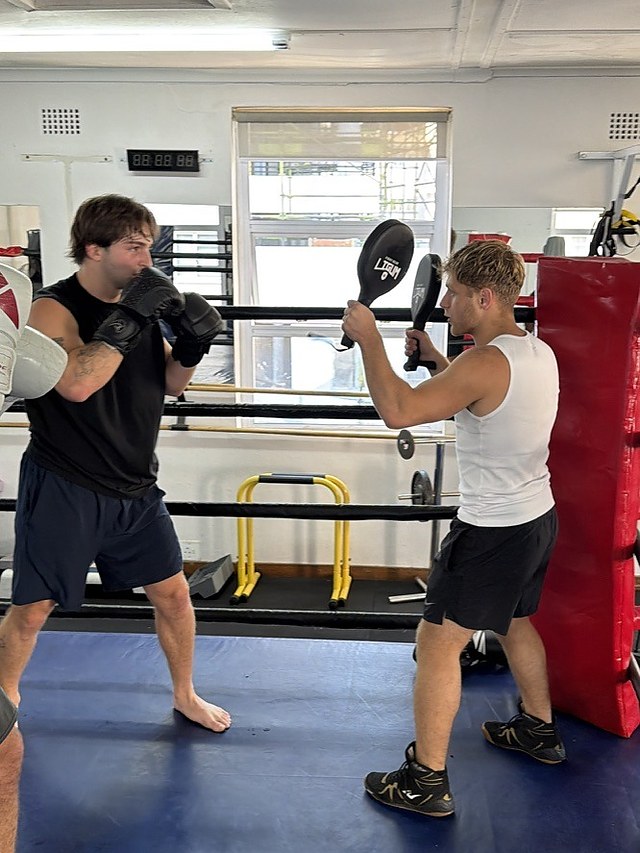 A client working the pads beside the heavy bag at Top Floor Boxing in Sea Point