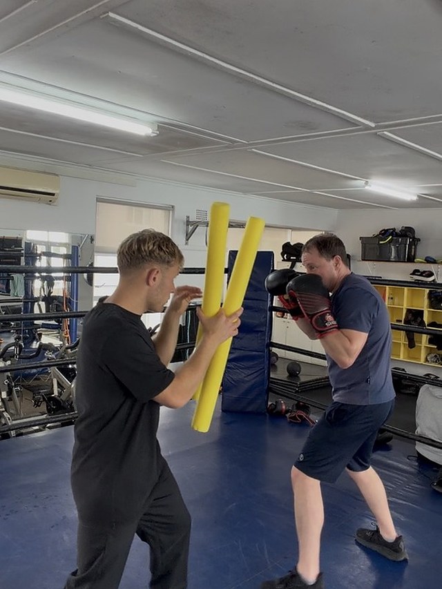 Reaction and head-movement drill with foam sticks in the ring at Top Floor Boxing.