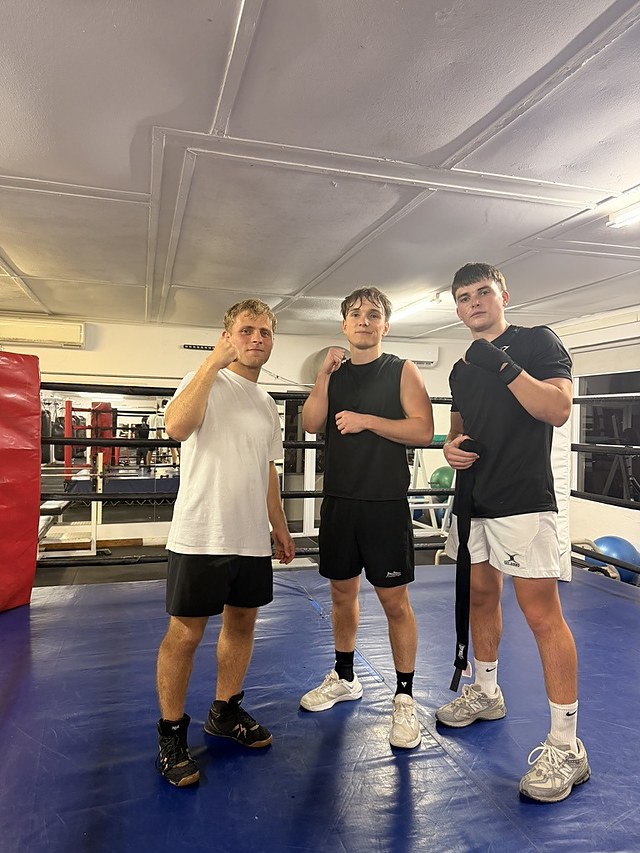 Three clients in the ring after a boxing session at Top Floor Boxing, Sea Point.